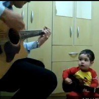 Em bé hát và đánh đàn