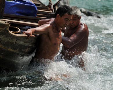 Đàn ông Trung Quốc khỏa thân kéo thuyền hút khách du lịch